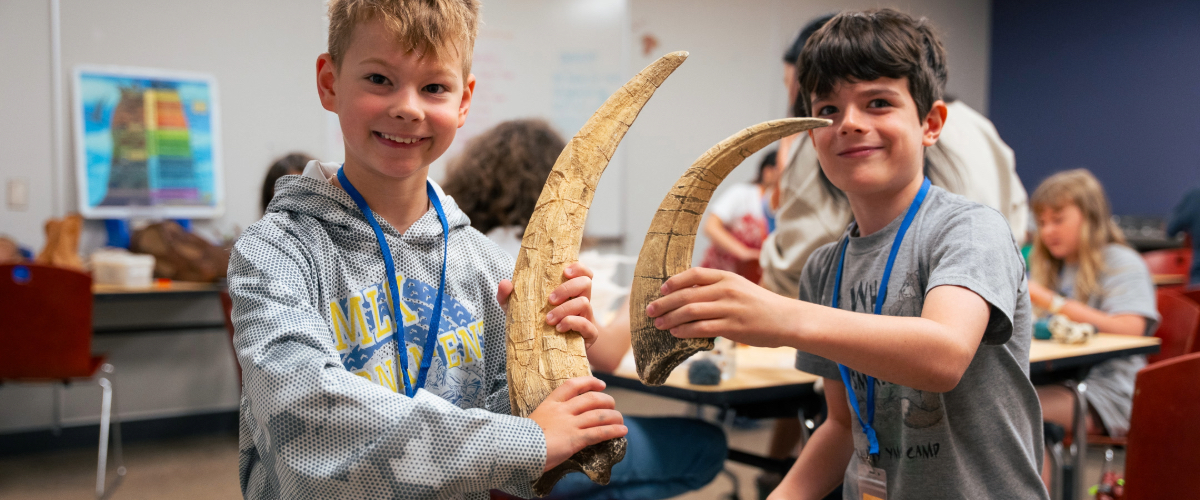 kids holding large casts of claws