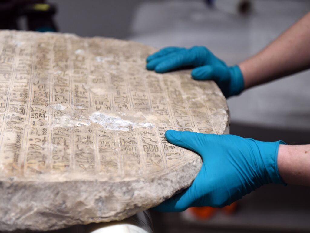 conservators moving stele wearing gloves