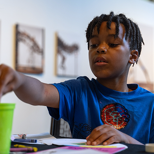A boy coloring at Super Science Saturday